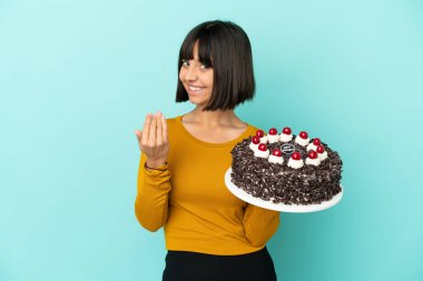 Genç melez kadın doğum günü pastası tutuyor ve davet ediyor. Gelmene sevindim.