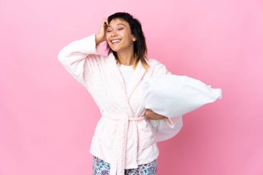 Pijamalı genç Uruguaylı kadın pembe arka planda gülüyor.