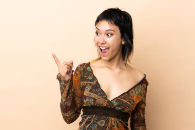 Bej arka planda izole edilmiş Hintli kadın parmağını kaldırarak çözümü bulmaya çalışıyor.