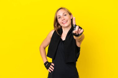 Beyaz arka planda izole edilmiş genç İngiliz kadın parmağını kaldırıyor ve gösteriyor