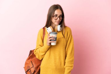 Soyutlanmış pembe arka planda genç bir bayan yan tarafa bakıyor.