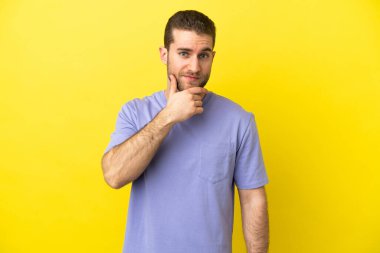 Sarışın yakışıklı adam izole edilmiş sarı arka plan düşüncesi