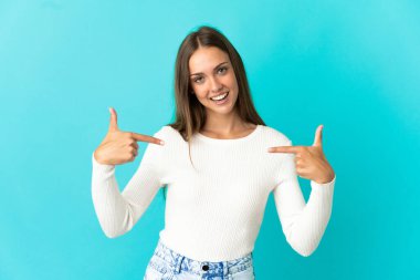 Soyutlanmış mavi arka plan gururlu ve kendini beğenmiş genç kadın.