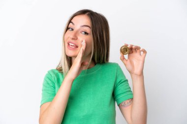 Elinde Bitcoin tutan genç Romen kadın beyaz arka planda izole edilmiş bir şekilde bir şeyler fısıldıyor