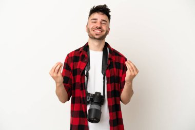 Beyaz arka planda izole genç fotoğrafçı para hareketi yapıyor.