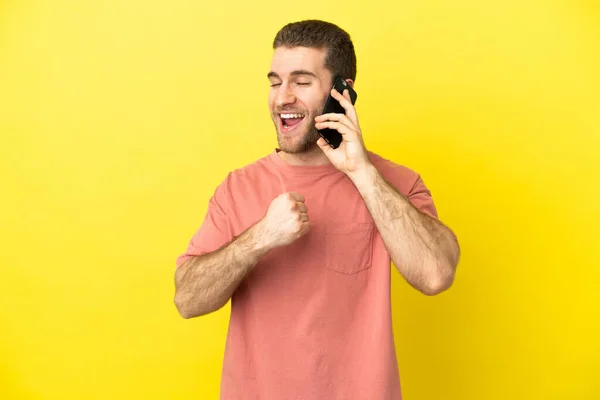 Handsome Blonde Man Using Mobile Phone Isolated Background Celebrating Victory — Stock Photo, Image