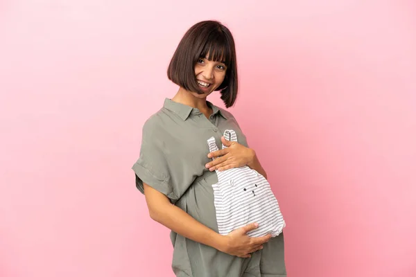 Frau Über Isolierten Hintergrund Schwanger Und Mit Babykleidung — Stockfoto