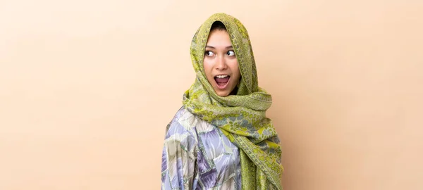 Indian Woman Isolated Beige Background Doing Surprise Gesture While Looking — Stock Photo, Image