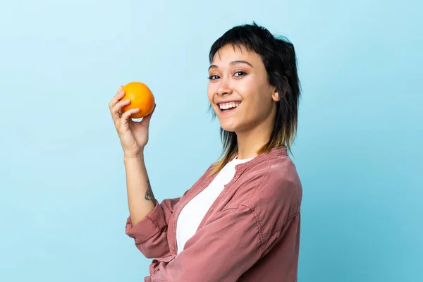 Ung Uruguayansk Kvinna Över Isolerad Blå Bakgrund Håller Orange — Stockfoto