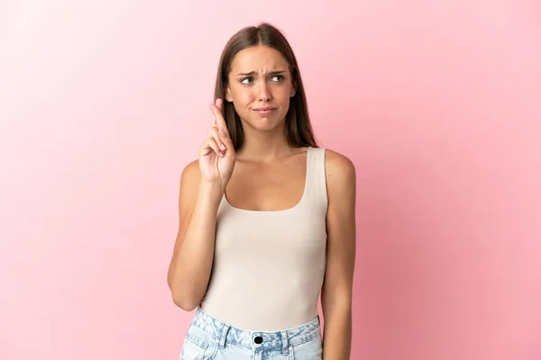 Mujer Joven Sobre Fondo Rosa Aislado Con Los Dedos Cruzando — Foto de Stock