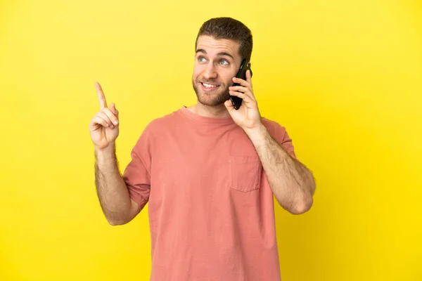 Handsome Blonde Man Using Mobile Phone Isolated Background Pointing Great — Stock Photo, Image