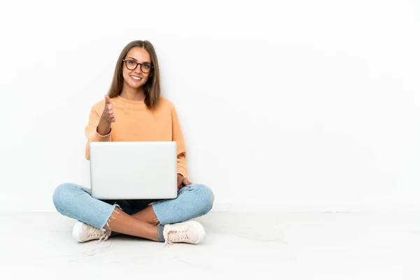 年轻女人坐在地板上 手里拿着笔记本电脑 握手示意关门 — 图库照片