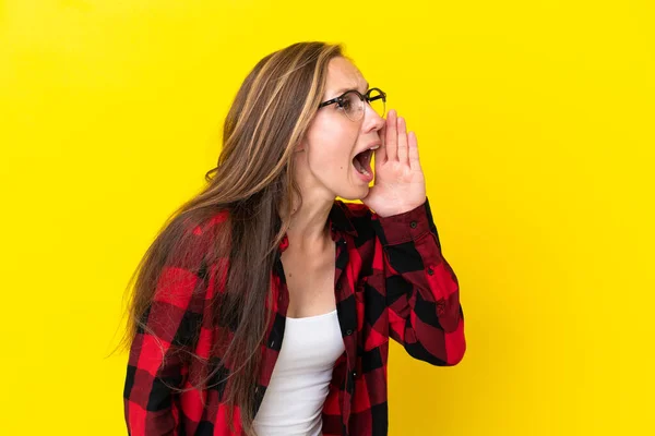 若い英語の女性は 黄色の背景に叫んで口を大きく横に開いて隔離 — ストック写真