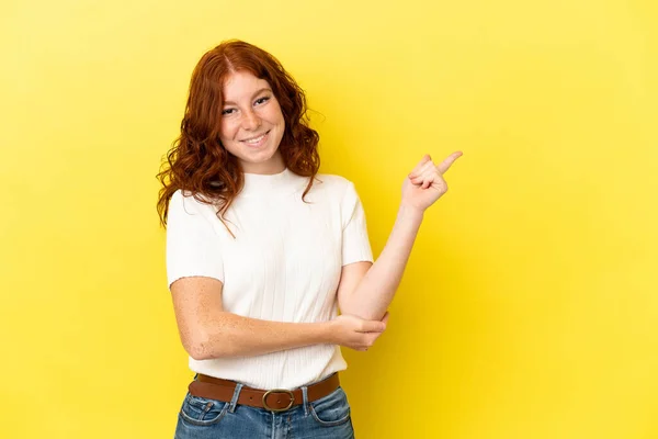 Adolescente Mulher Avermelhada Isolado Fundo Amarelo Apontando Dedo Para Lado — Fotografia de Stock