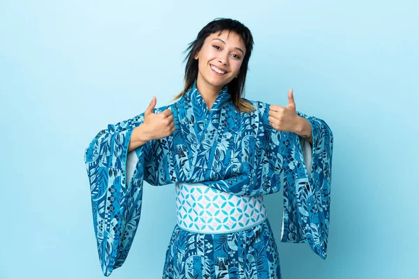 Mujer Joven Usando Kimono Sobre Fondo Azul Aislado Con Pulgares —  Fotos de Stock