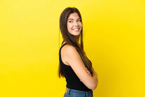 若いブラジル人女性は黄色の背景に孤立し 側を見て笑顔 — ストック写真