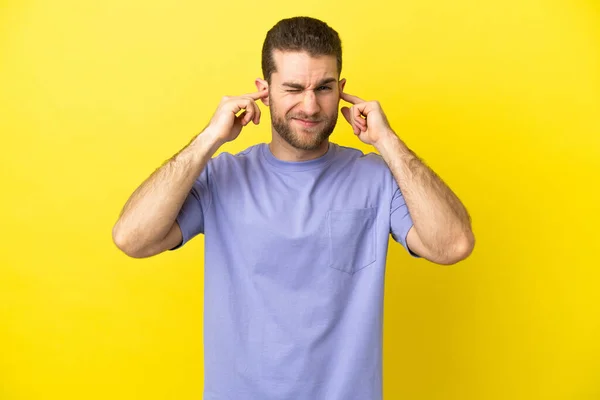 Guapo Rubia Hombre Sobre Aislado Amarillo Fondo Frustrado Cubriendo Oídos — Foto de Stock