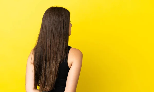 Mujer Brasileña Joven Aislada Sobre Fondo Amarillo Posición Espalda Mirando —  Fotos de Stock