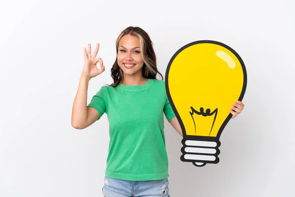 Teenager Russian Girl Isolated Blue Background Holding Bulb Icon Doing — Stock Photo, Image