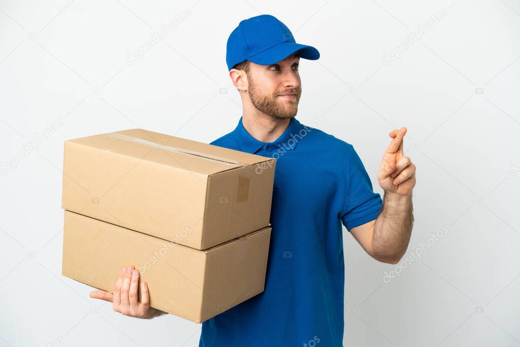 Delivery man over isolated white background with fingers crossing and wishing the best