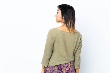 Genç Uruguaylı kız izole edilmiş beyaz arka planda ve yan bakıyor.