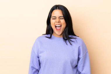 Genç Latin bir kadın arka planda, ağzı açık bağırıyor.