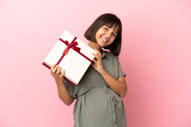 Tecrit edilmiş bir kadın hamile ve elinde bir hediye var.