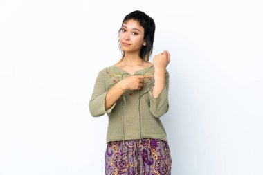 Genç Uruguaylı kız, soyutlanmış beyaz arka planda geç kalma jesti yapıyor.