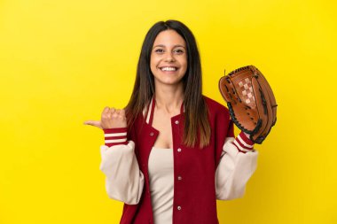 Beyzbol oynayan, sarı arka planda izole edilmiş beyaz bir kadın bir ürünü sunmak için yan tarafa bakıyor.