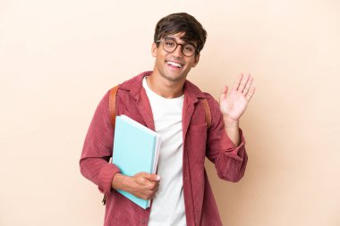 Kafkasyalı genç bir öğrenci arka planda izole edilmiş mutlu bir ifadeyle selamlıyor.