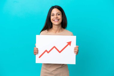 Arkaplanda mutlu bir ifadeyle büyüyen bir istatistik ok sembolü taşıyan bir tabela tutan izole edilmiş genç bir kadın.