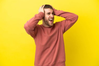 Sarışın yakışıklı adam izole edilmiş sarı arka planda baskı altında.