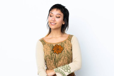 Genç Uruguaylı kız soyutlanmış beyaz arka plan üzerinden yan tarafa bakıyor ve gülümsüyor.