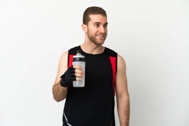 Yakışıklı sarışın adam izole edilmiş beyaz arka planda spor su şişesiyle