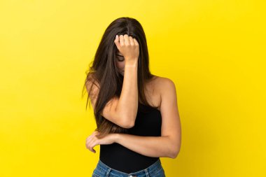 Genç Brezilyalı kadın sarı arka planda izole edilmiş, baş ağrısı var.