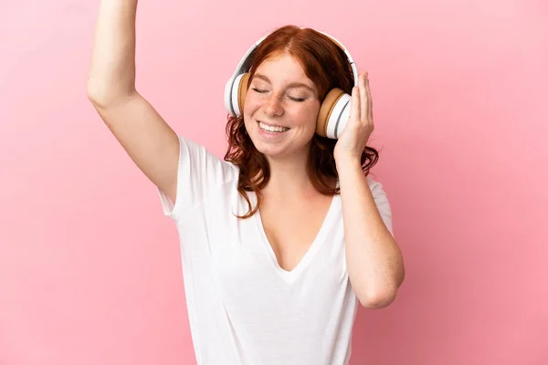 Adolescente Mujer Rojiza Aislada Sobre Fondo Rosa Escuchando Música Bailando —  Fotos de Stock