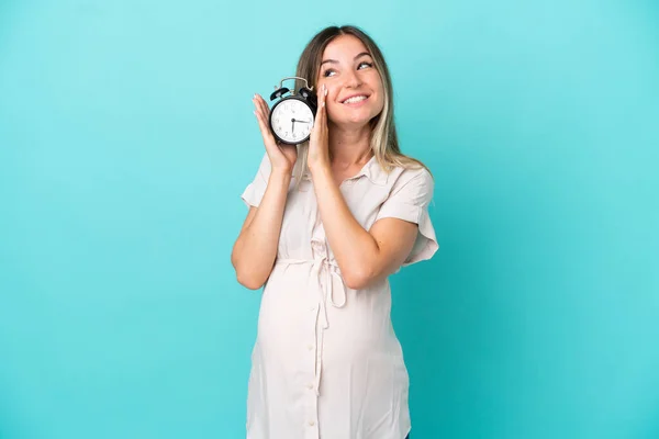 Joven Rumana Aislada Sobre Fondo Azul Embarazada Sosteniendo Reloj — Foto de Stock