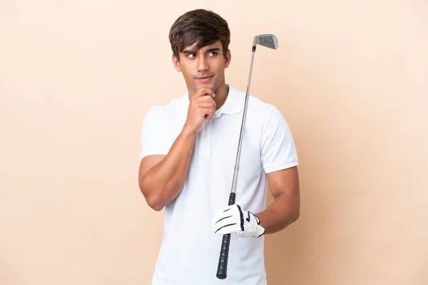Joven Jugador Golf Hombre Aislado Sobre Fondo Ocre Teniendo Dudas —  Fotos de Stock