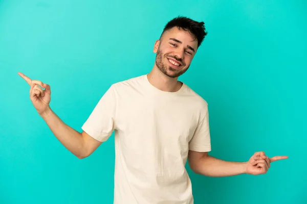 Jeune Homme Caucasien Isolé Sur Fond Bleu Pointant Doigt Les — Photo