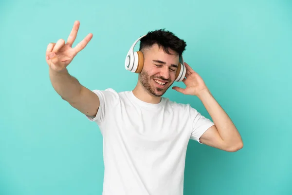 Νεαρός Καυκάσιος Άνδρας Απομονωμένος Μπλε Φόντο Ακούγοντας Μουσική Και Τραγουδώντας — Φωτογραφία Αρχείου
