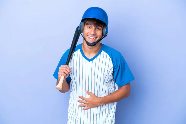 野球Caucasian男選手とともにヘルメットとバット隔離上の青の背景笑顔多く — ストック写真