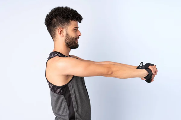 Ung Marockansk Man Isolerad Blå Bakgrund Stretching Arm — Stockfoto