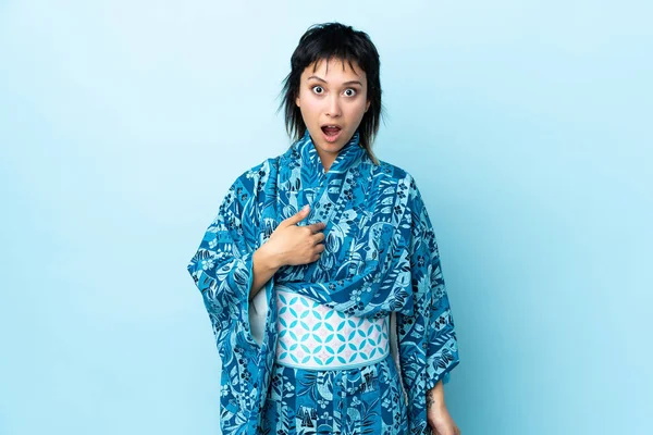 Mujer Joven Que Usa Kimono Sobre Fondo Azul Aislado Apuntándose —  Fotos de Stock