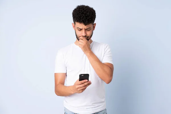 Joven Hombre Marroquí Aislado Sobre Fondo Azul Pensando Enviando Mensaje —  Fotos de Stock