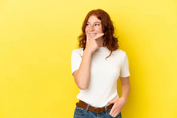 Adolescente Mulher Avermelhada Isolado Fundo Amarelo Olhando Para Lado Sorrindo — Fotografia de Stock