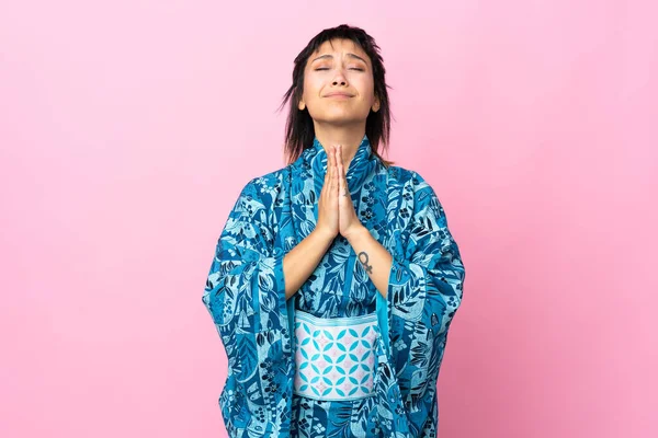 Ung Kvinna Bär Kimono Över Isolerad Blå Bakgrund Håller Handflatan — Stockfoto