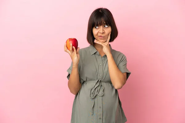 Frau Mit Isoliertem Hintergrund Schwanger Und Beim Denken Einen Apfel — Stockfoto
