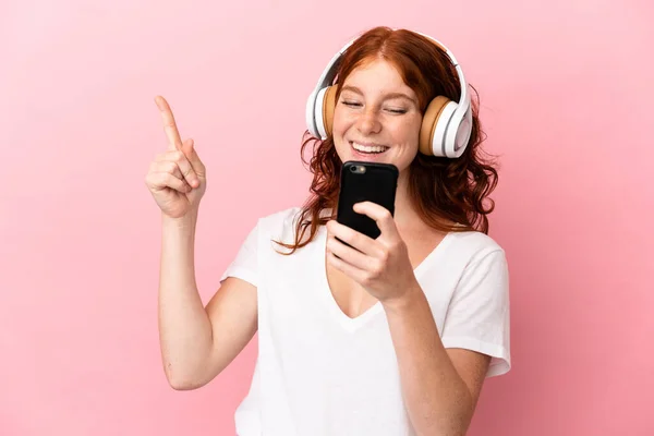 Adolescente Femme Rougeâtre Isolée Sur Fond Rose Écoutant Musique Avec — Photo