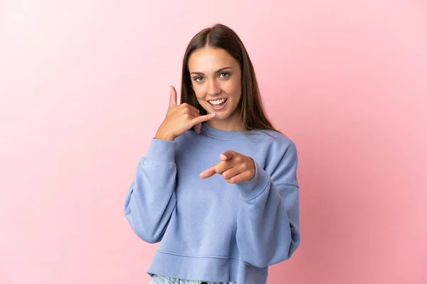 Jeune Femme Sur Fond Rose Isolé Faisant Geste Téléphonique Pointant — Photo