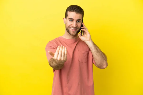 Handsome Blonde Man Using Mobile Phone Isolated Background Inviting Come — Stock Photo, Image